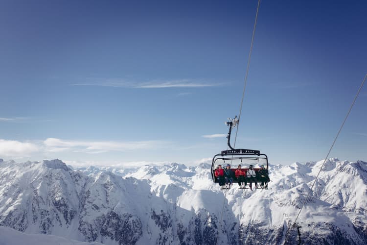 Friends taking chairlift to top of Austrian Mountain