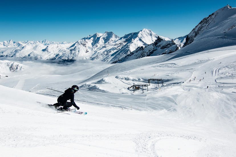 Skier carving down slope in Austrian ski resort of Saas Fee