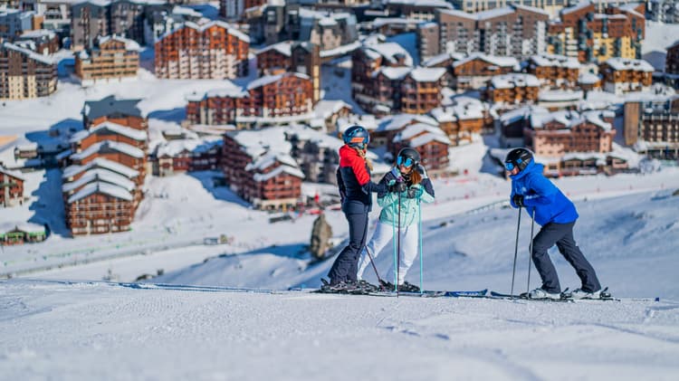 friends taking a break overlooking the village of val thorens