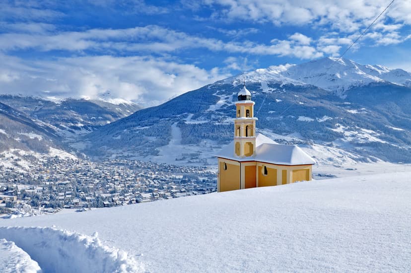 Isolated snow-capped church above ski resort of Bormio