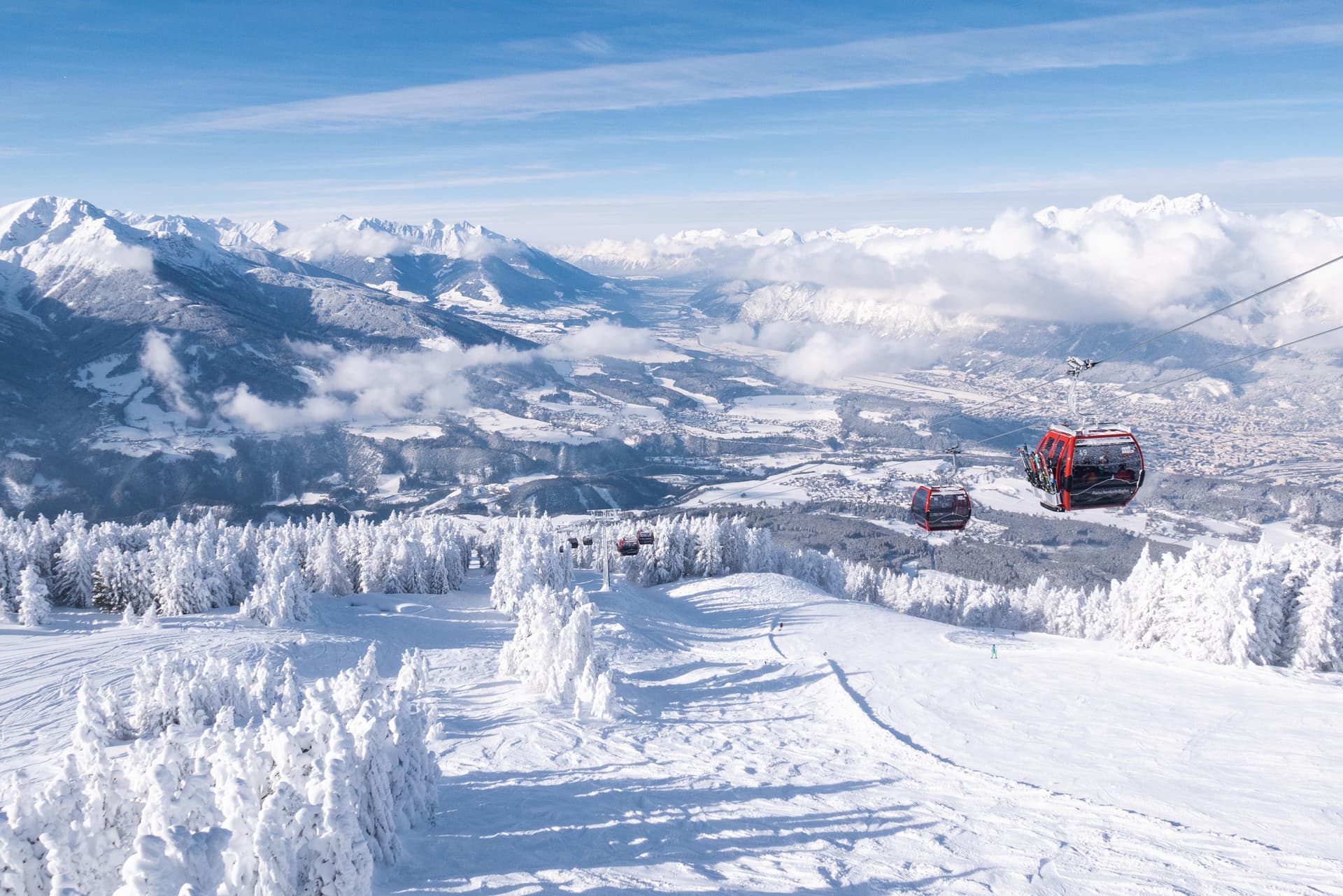 Gondola taking skiiers up mountain in Igls