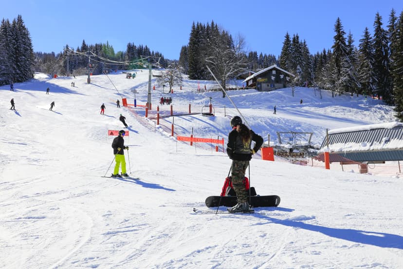 Skiers and snowboarders at the bottom of a slope