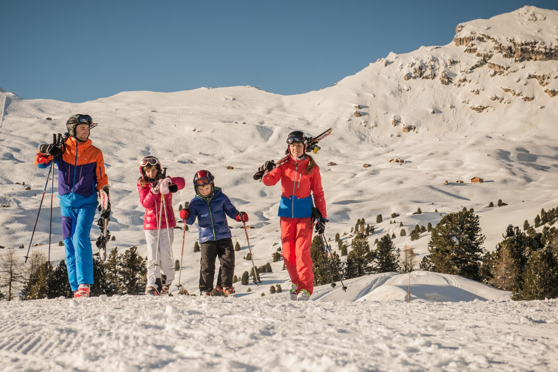 Family carrying skis to top of Italian ski resort mountain