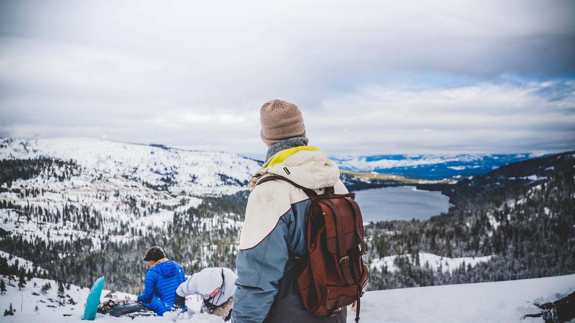 Group of friends sledging with Lake Tahoe in the background