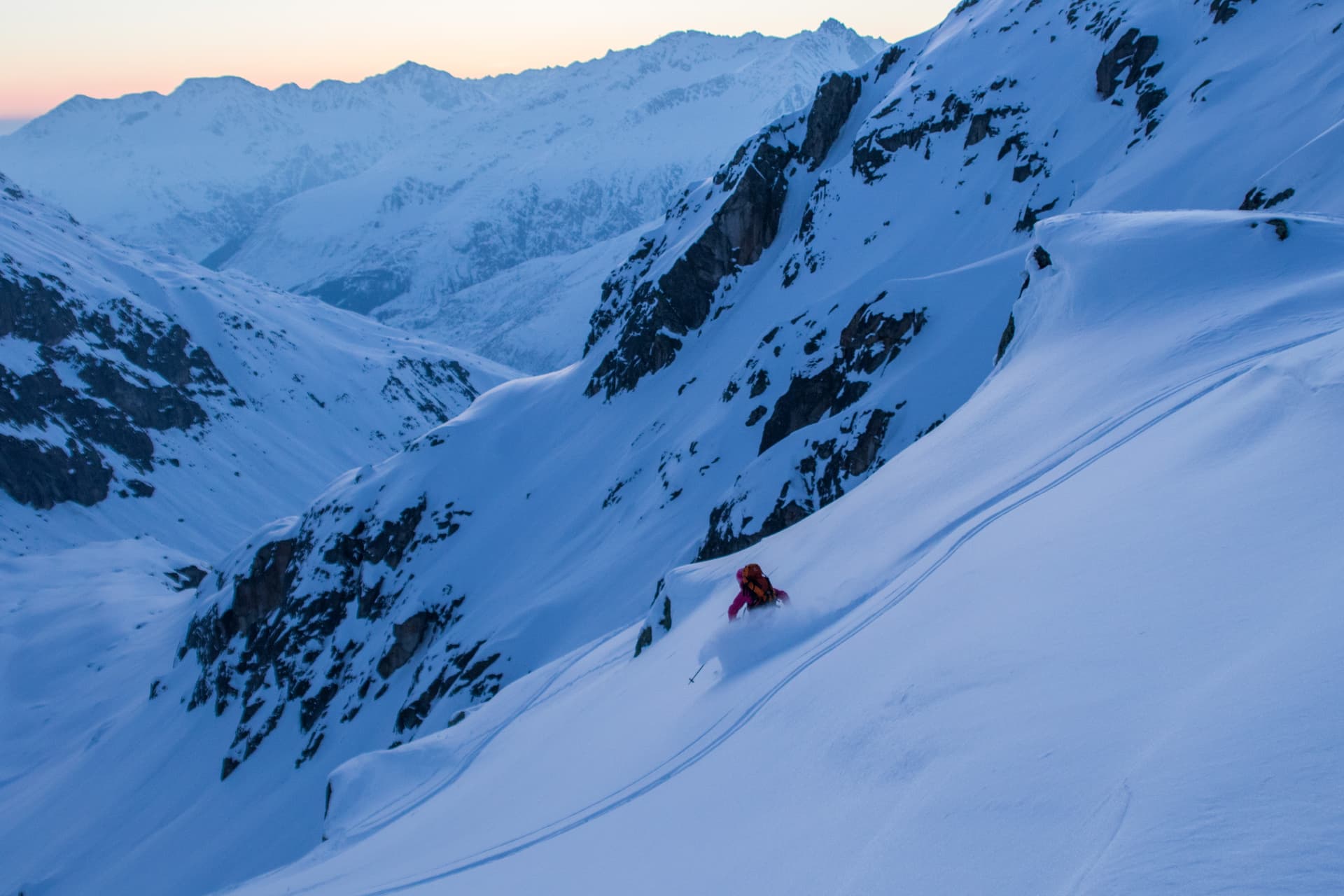 Skier carving through off piste powder