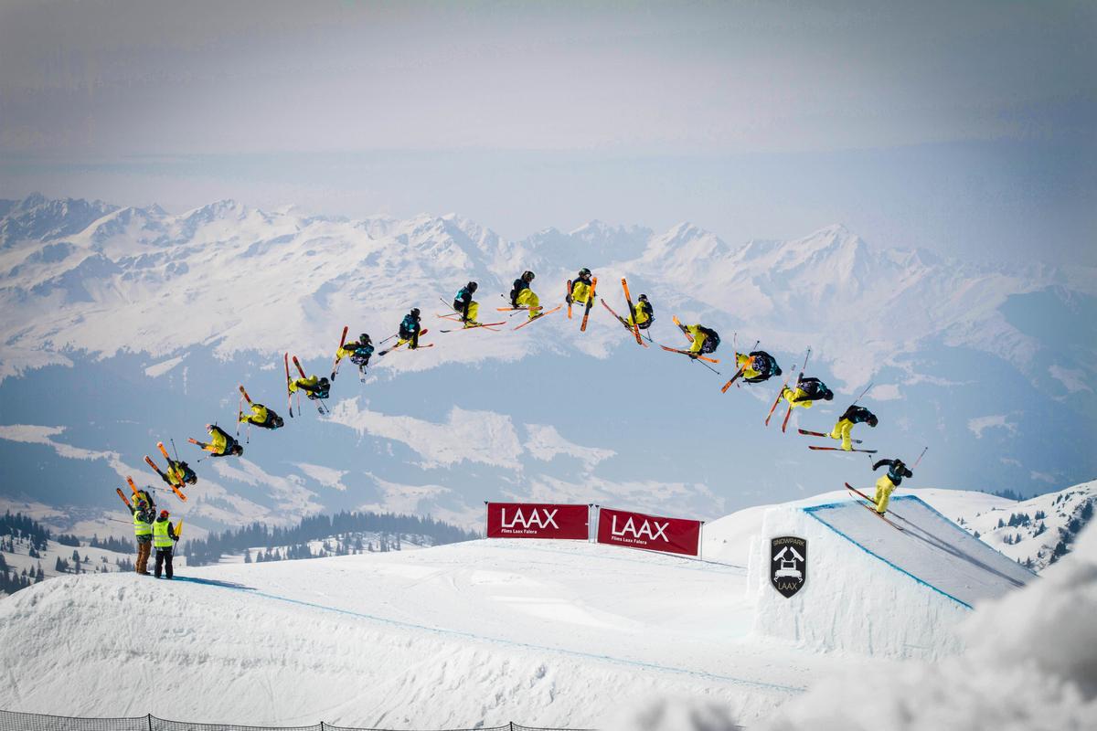 Skiier performing trick over big jump at Laax