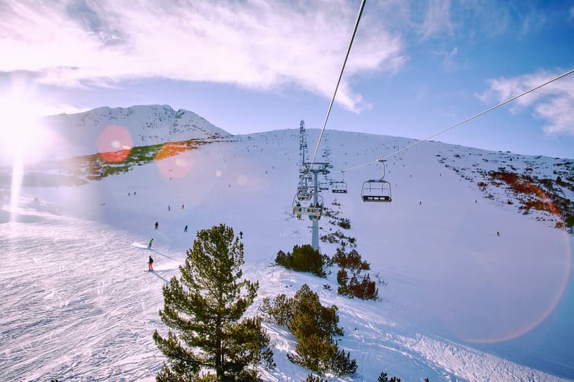 Chairlift transporting skiiers to top of mountain with ski slope below