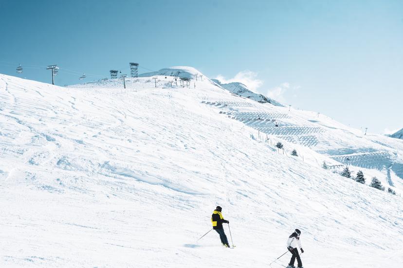 2 Skiiers skiing down slope