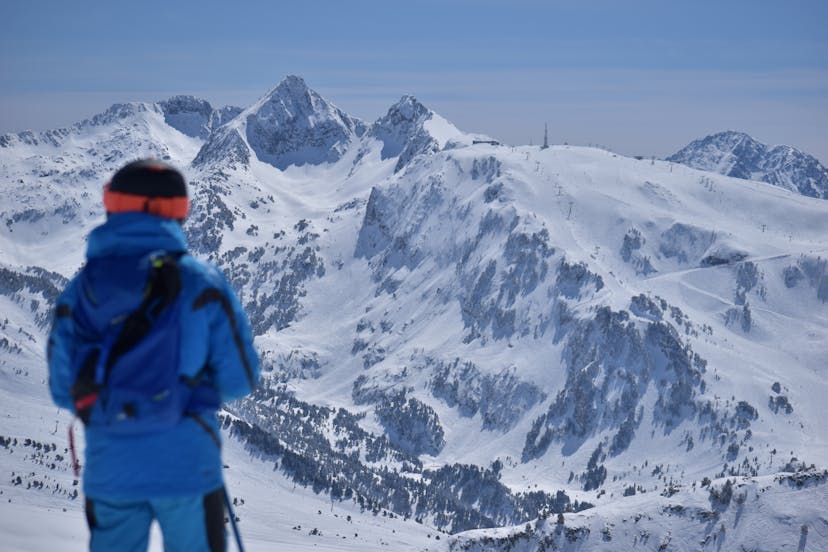 Skiier overlooking snowy mountain range in Baqueira Beret resort in Spain