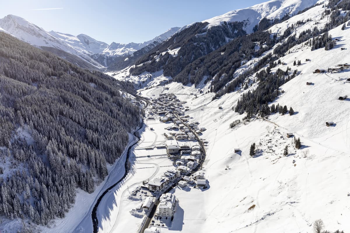 a snow covered valley with trees and a mountain range in the background at Tux ski resort