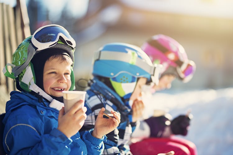 Children on a ski holiday enjoying a hot chocolate