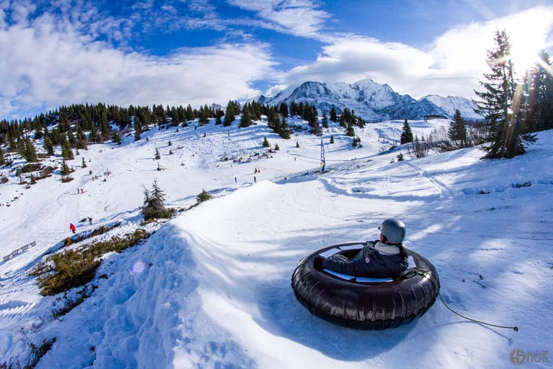 Child enjoying snow tubing down French Alps slope in Les Houches