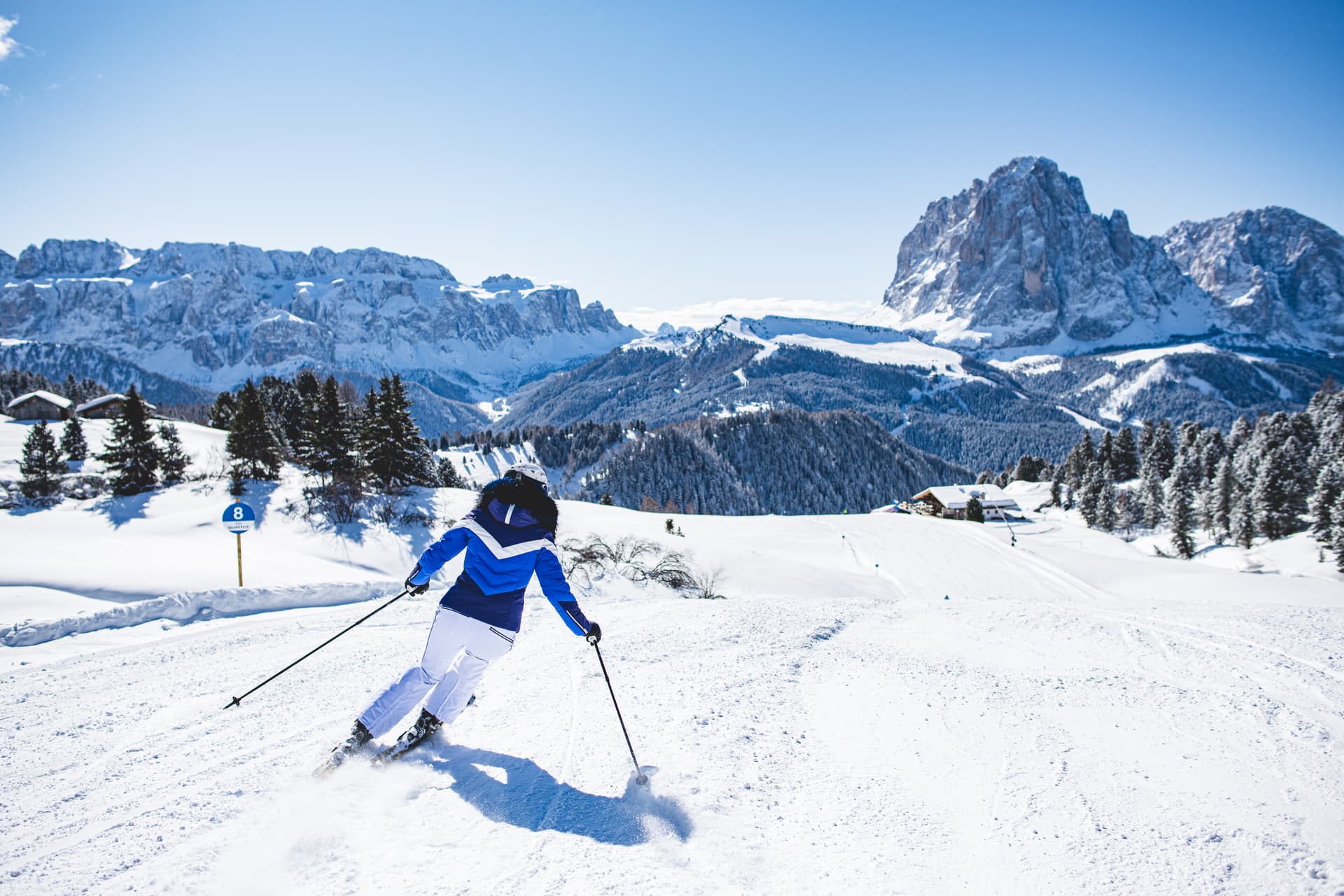 Skiier skiing down ski slope on sunny day